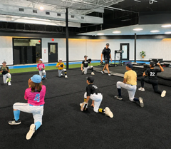 10U Fall Baseball players training with a coach at Advanced Athletics Club