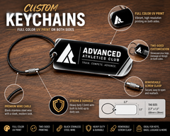 Three custom printed keychains on a wood table showing team and business designs